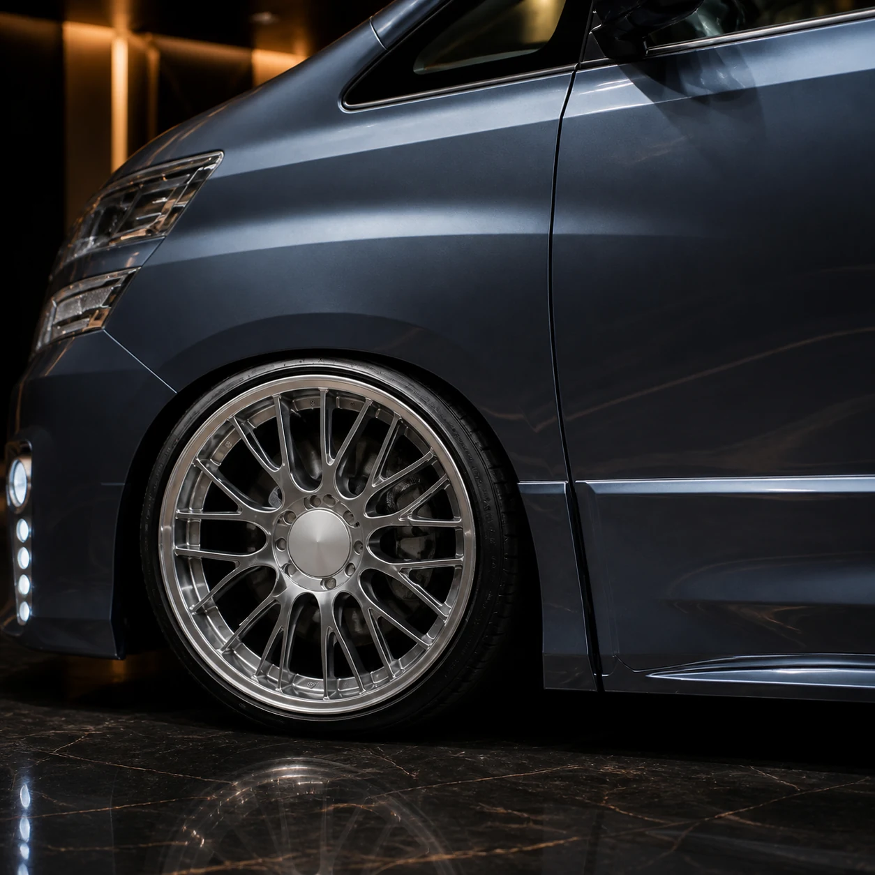 Toyota Vellfire 20 early silver blank-centre mesh wheel arch and Grand Tourer side-step AI concept detail